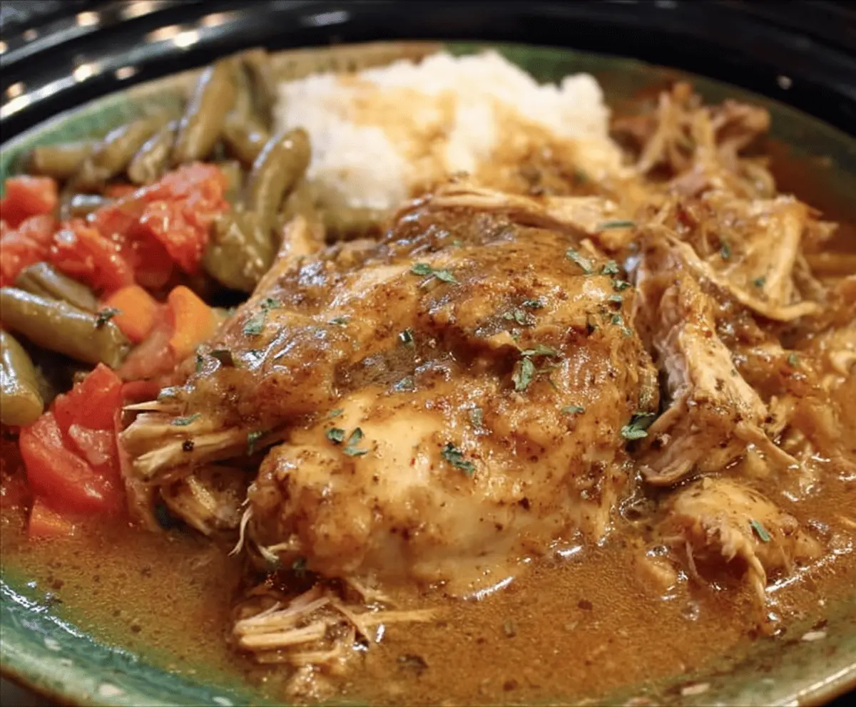 Delicious Crock Pot Mississippi Chicken topped with melted cheese and garnished with fresh herbs, served in a bowl