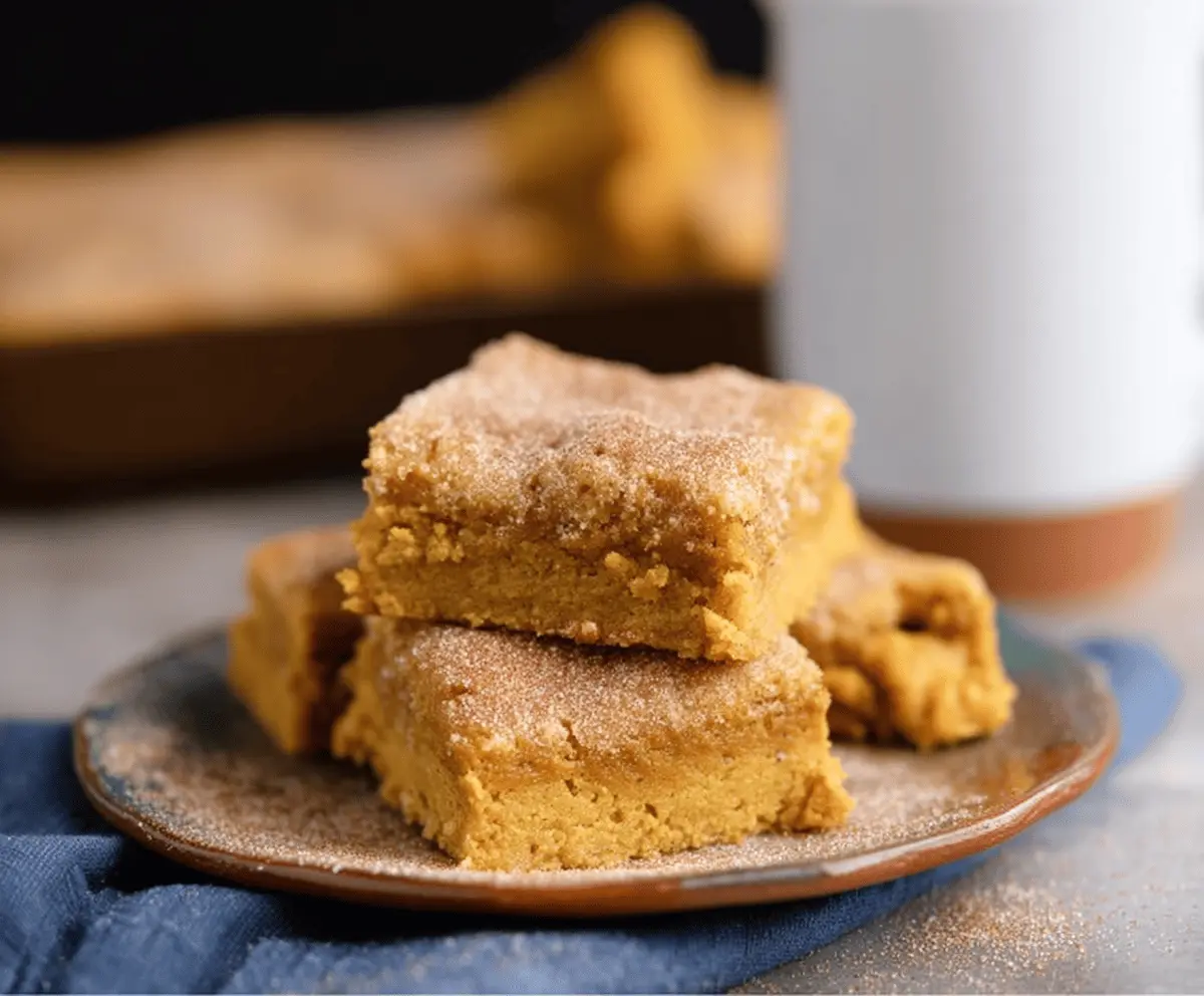 Delicious Pumpkin Snickerdoodle Bars topped with cinnamon sugar, perfect for fall baking and holiday desserts.