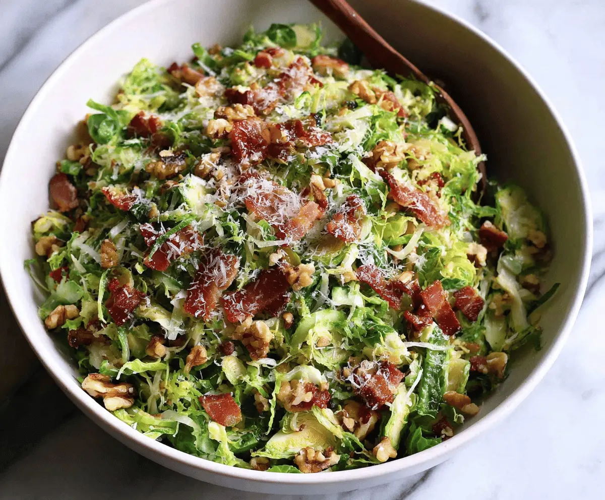 A fresh shaved Brussels sprout salad topped with crispy bacon, grated Parmesan cheese, and toasted walnuts.