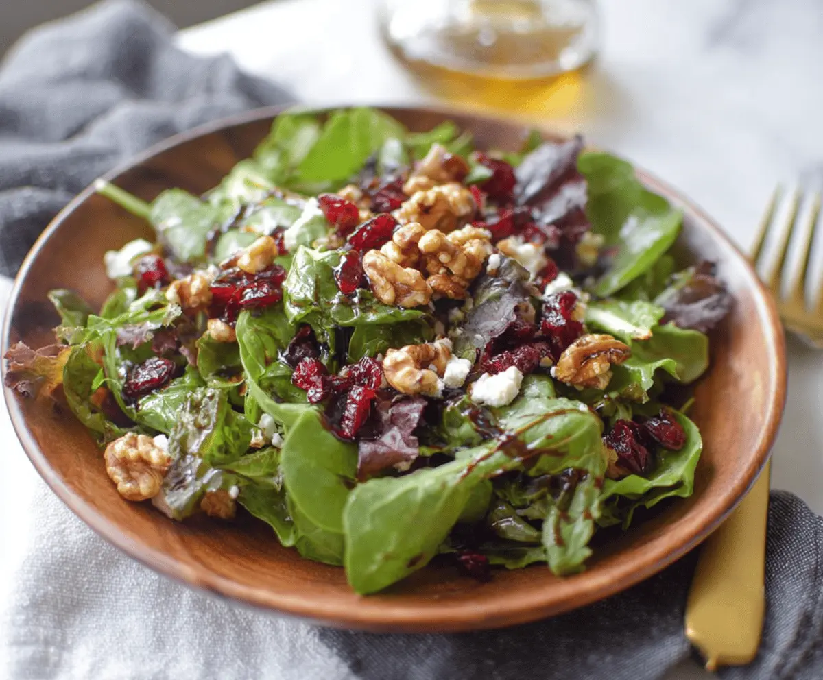 Fresh cranberry, walnut, and goat cheese salad drizzled with fig balsamic dressing for a flavorful and healthy meal.