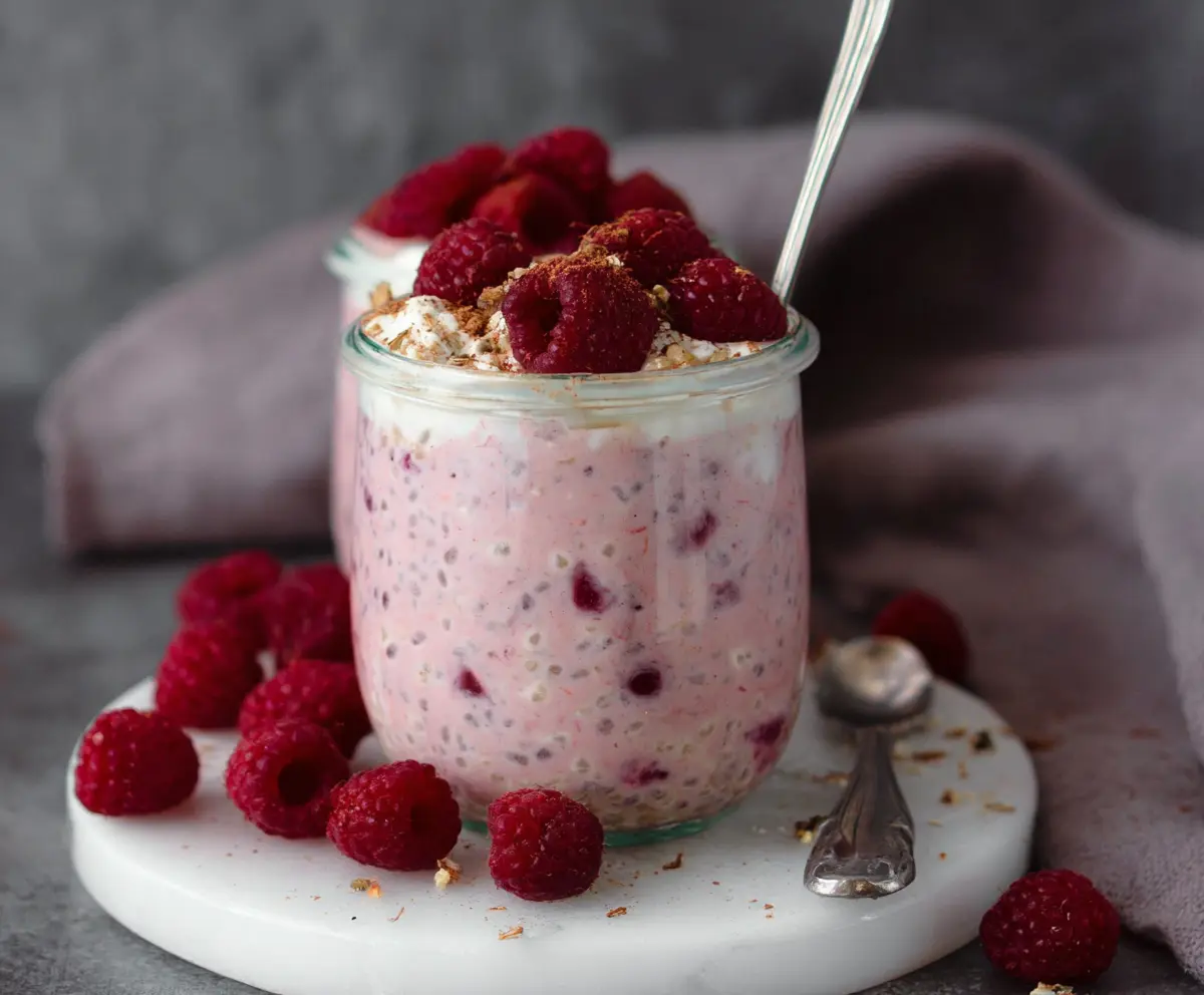 Healthy raspberry overnight oats recipe with fresh berries and creamy oats in a jar.