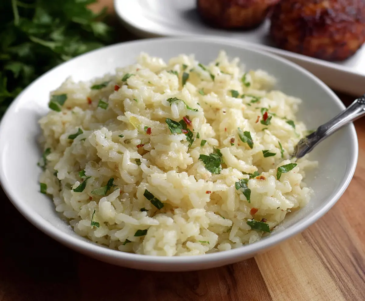 Creamy garlic Parmesan rice served as a flavorful side dish with fresh herbs.
