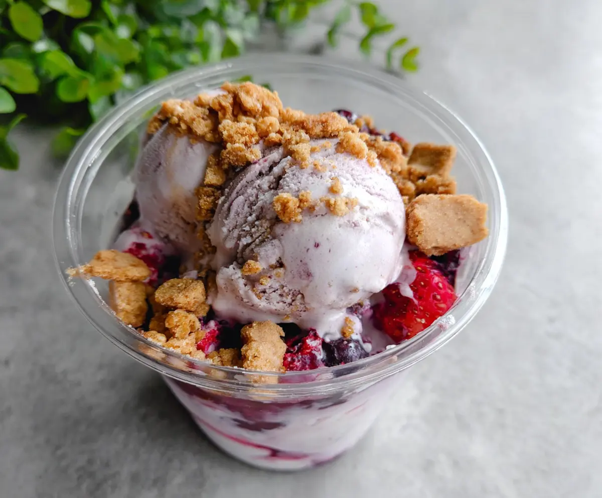 Delicious Berry Crumble Ice Cream topped with fresh berries and crunchy crumble pieces
